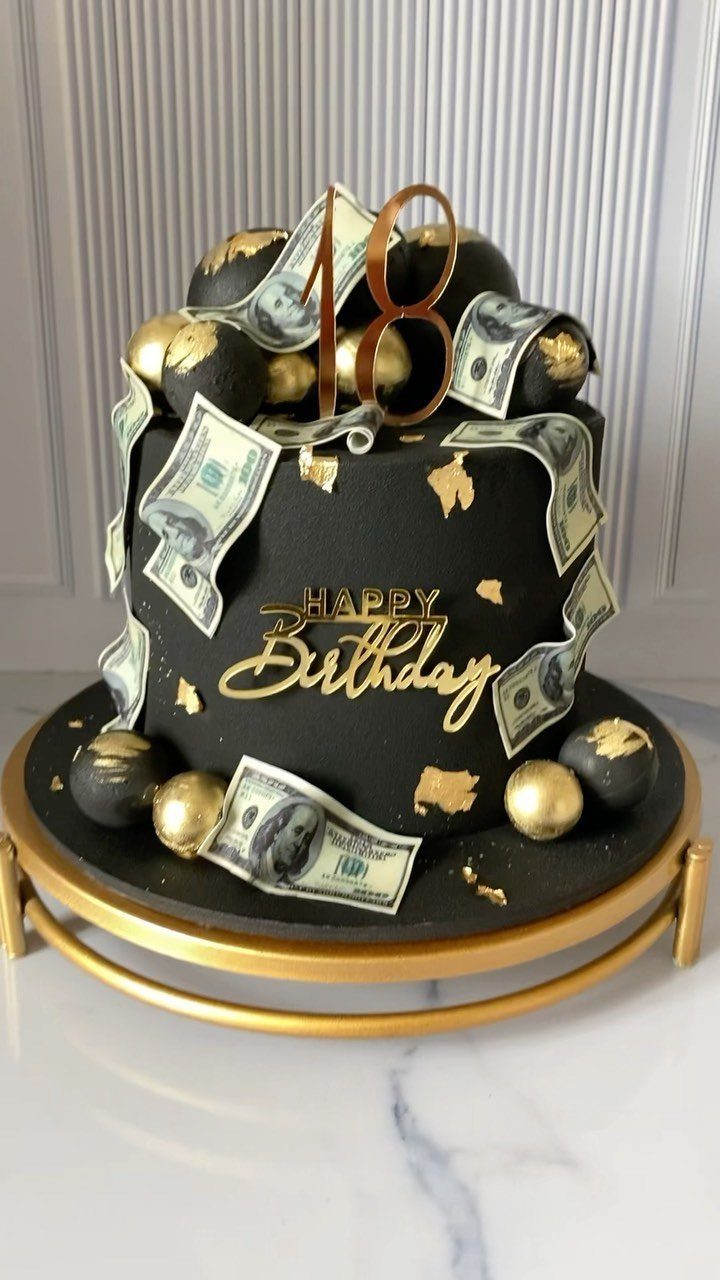 Black birthday cake with gold accents, edible money, and a gold 18 topper.