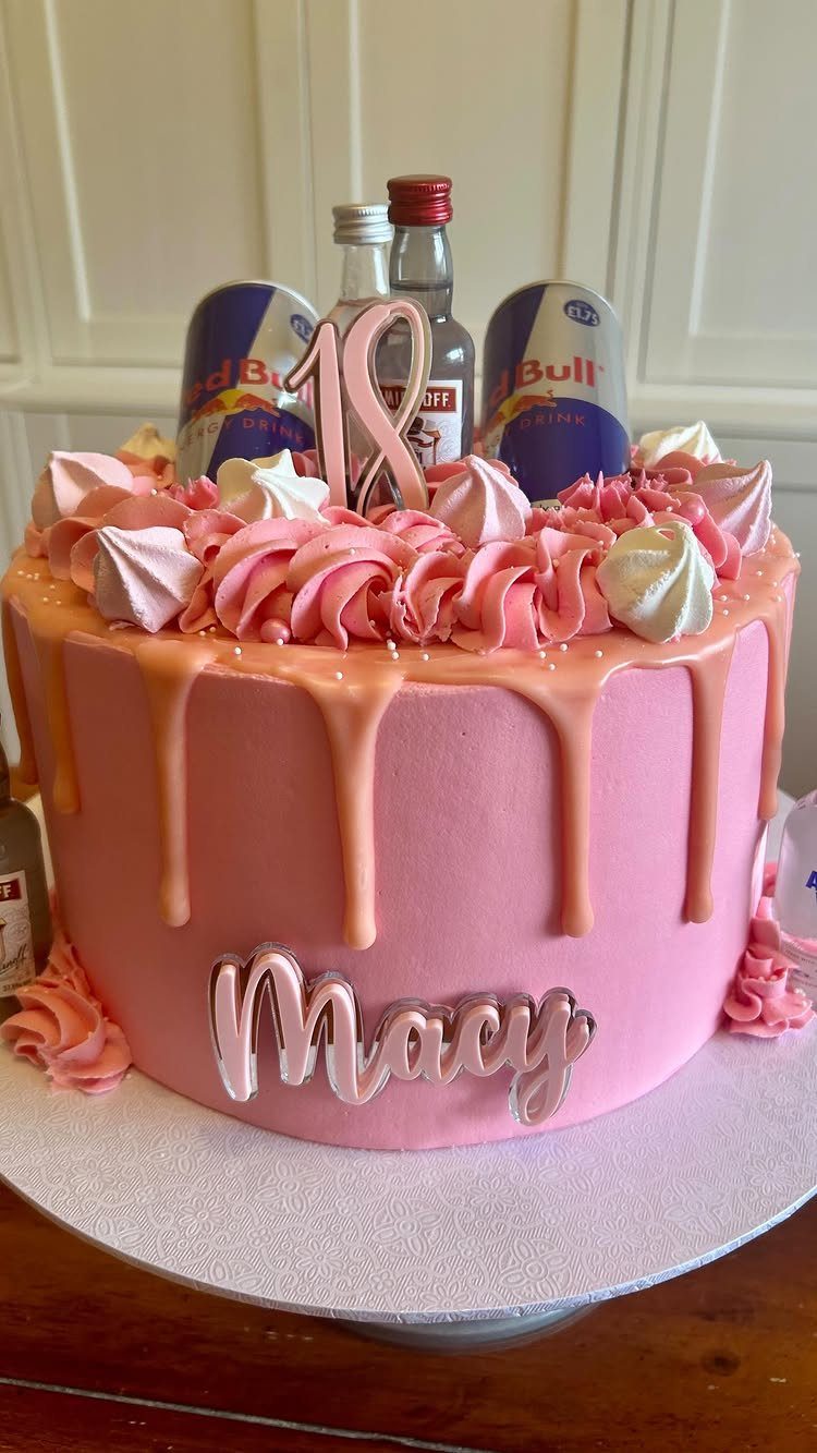 Pink drip cake with meringue kisses, Red Bull cans, and gold 18 topper
