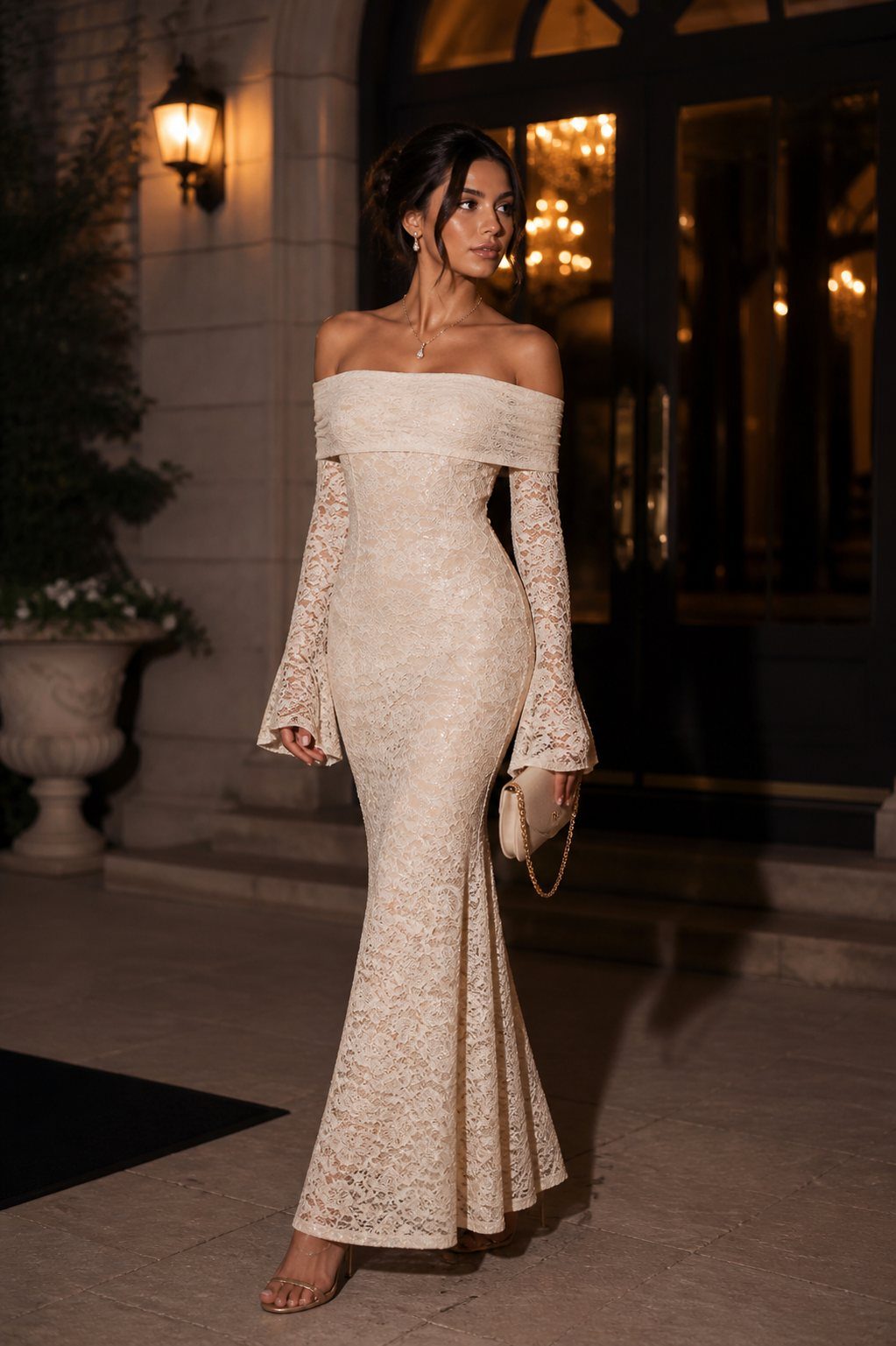 Woman in a white off-the-shoulder lace mermaid dress standing outdoors at night.