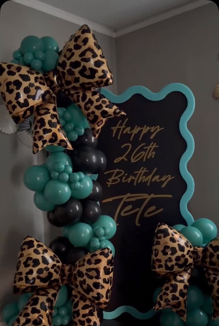 Birthday decoration with leopard print bows, teal and black balloons, and 26th birthday sign.