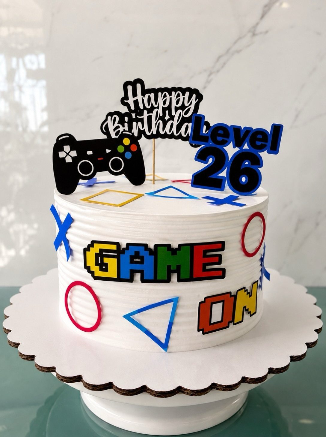 Gaming themed birthday cake with Level 26 topper and game controller decoration