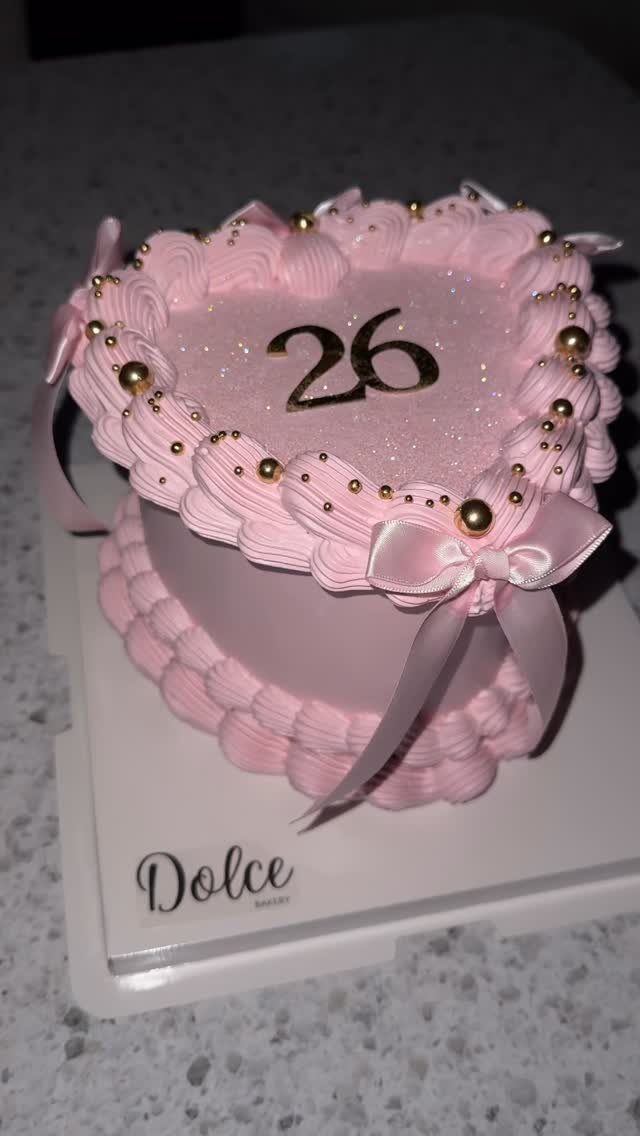 Heart-shaped pink vintage cake with gold pearls and the number 26 on top.
