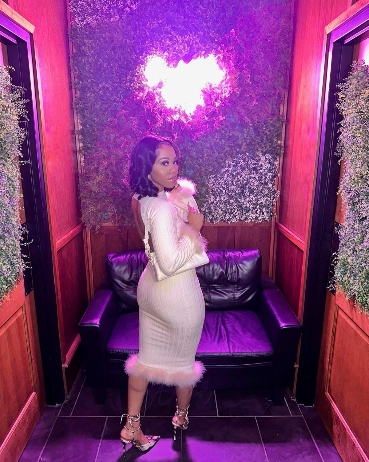 Woman in white ribbed midi dress with faux fur trim and silver heels