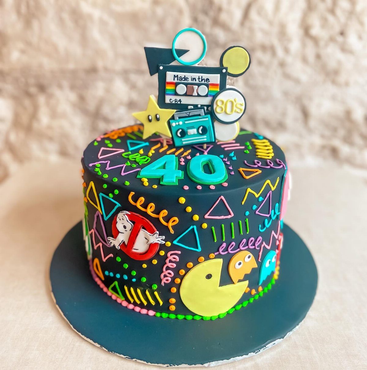 80s themed birthday cake with Pac-Man, Ghostbusters, and a teal number 40