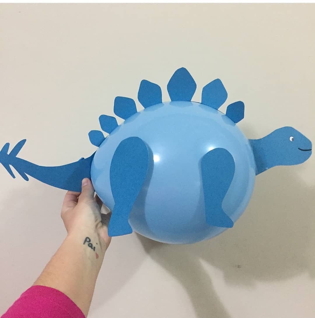 Blue balloon dinosaur decoration with cardstock plates, head, and tail held by hand.