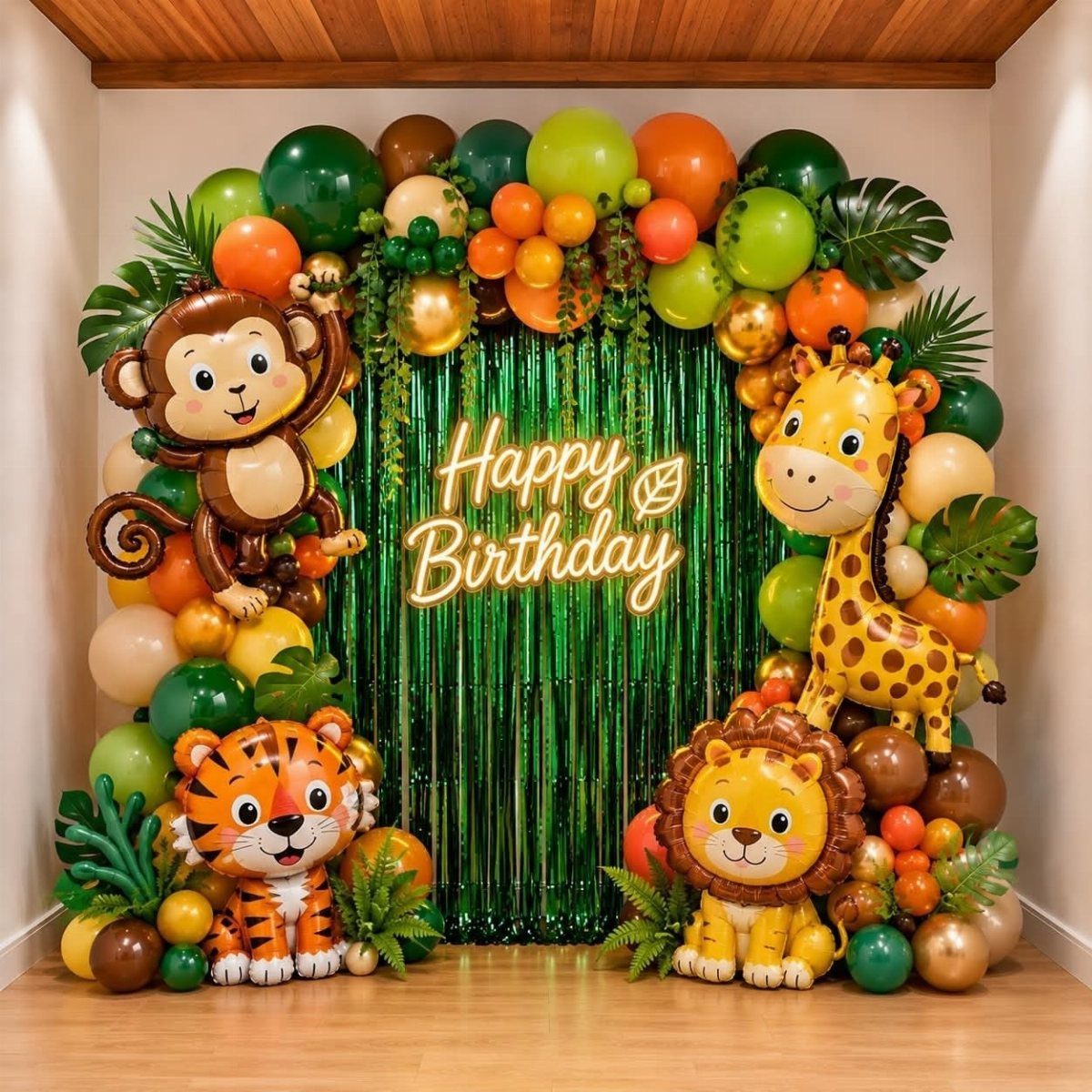 Jungle themed birthday backdrop with animal balloons and a green tinsel curtain.