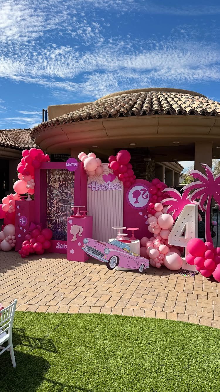 Pink Barbie themed party decorations with balloons, a large number 4, and car cutout.