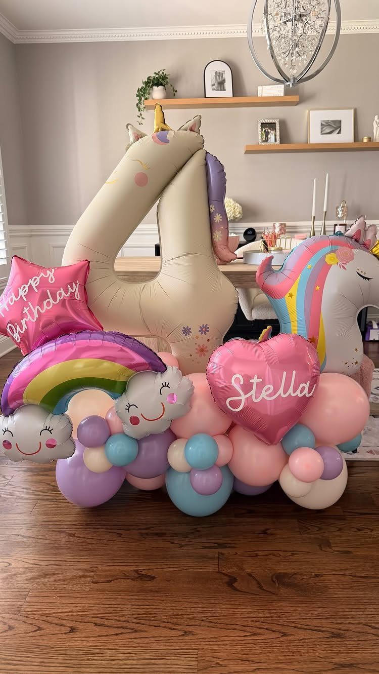 Unicorn themed birthday balloon arrangement with a large number four and rainbow colors.