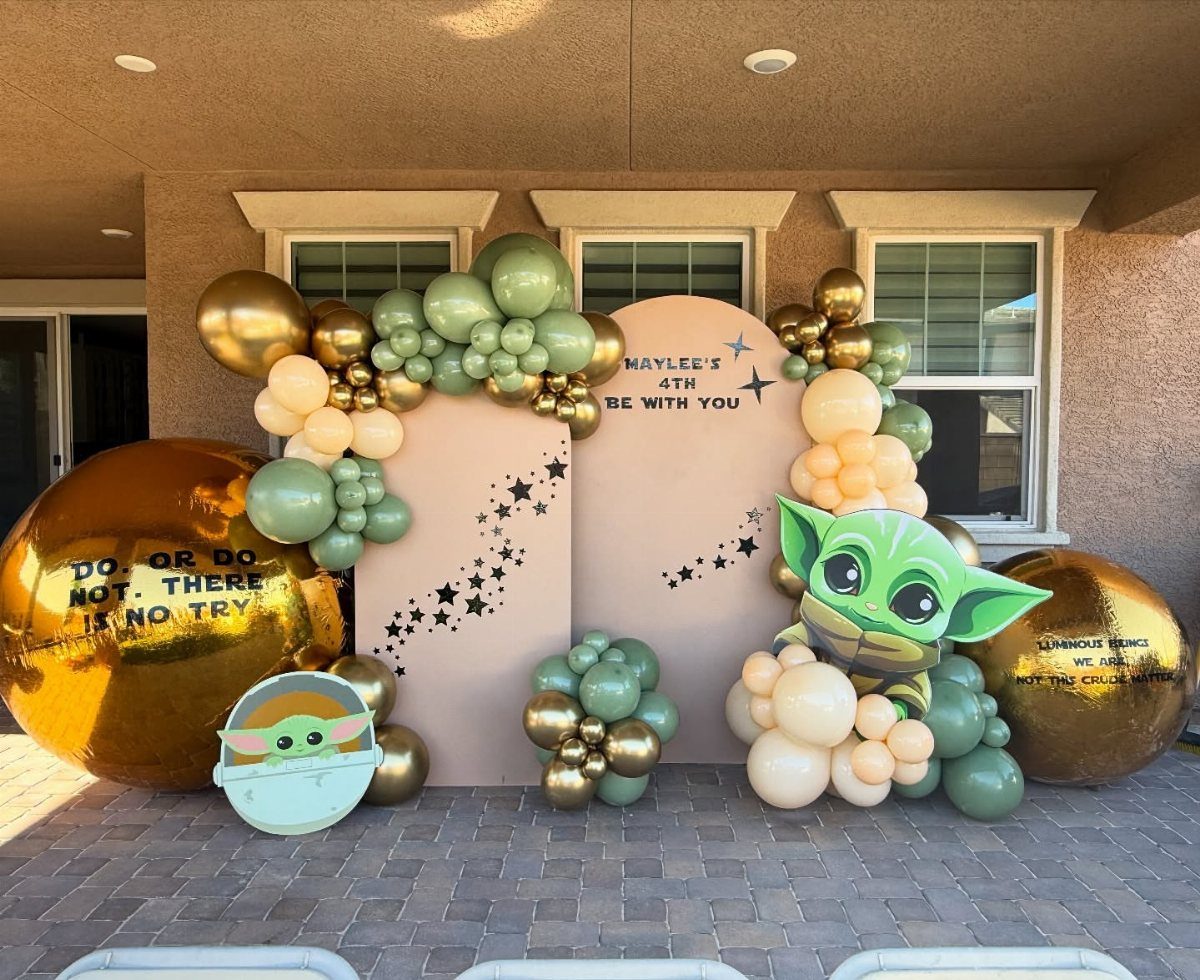 Star Wars themed 4th birthday decorations with gold and green balloons and Grogu cutouts