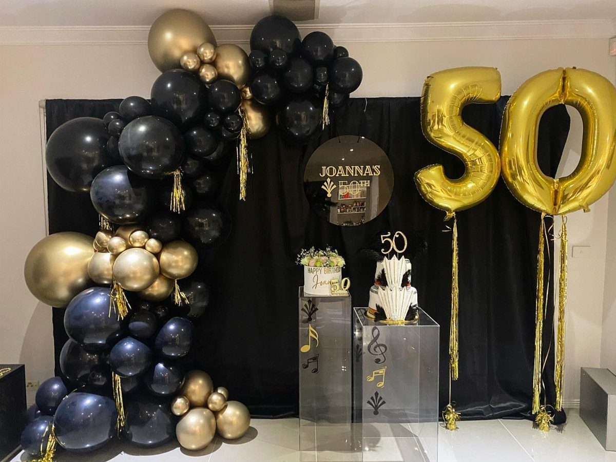 Black and gold balloon arch with gold number 50 balloons for a party.