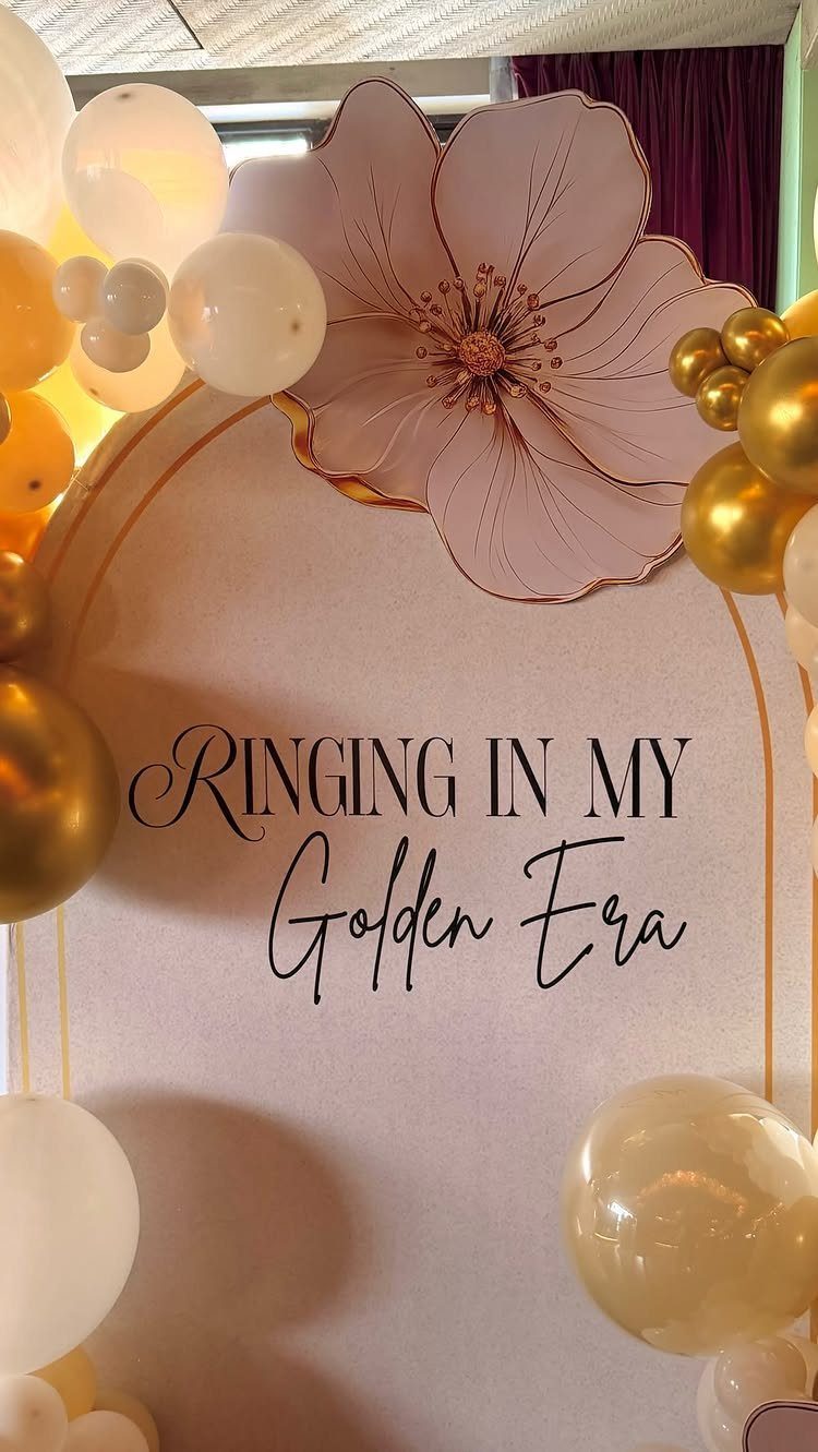 Party backdrop with gold and white balloons and a Golden Era sign.