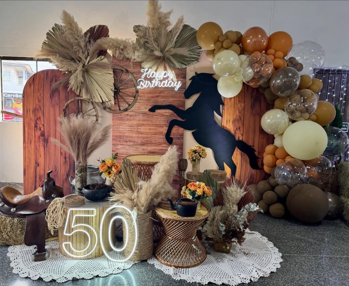 Rustic 50th birthday party decor with horse silhouette, brown balloons, and pampas grass.