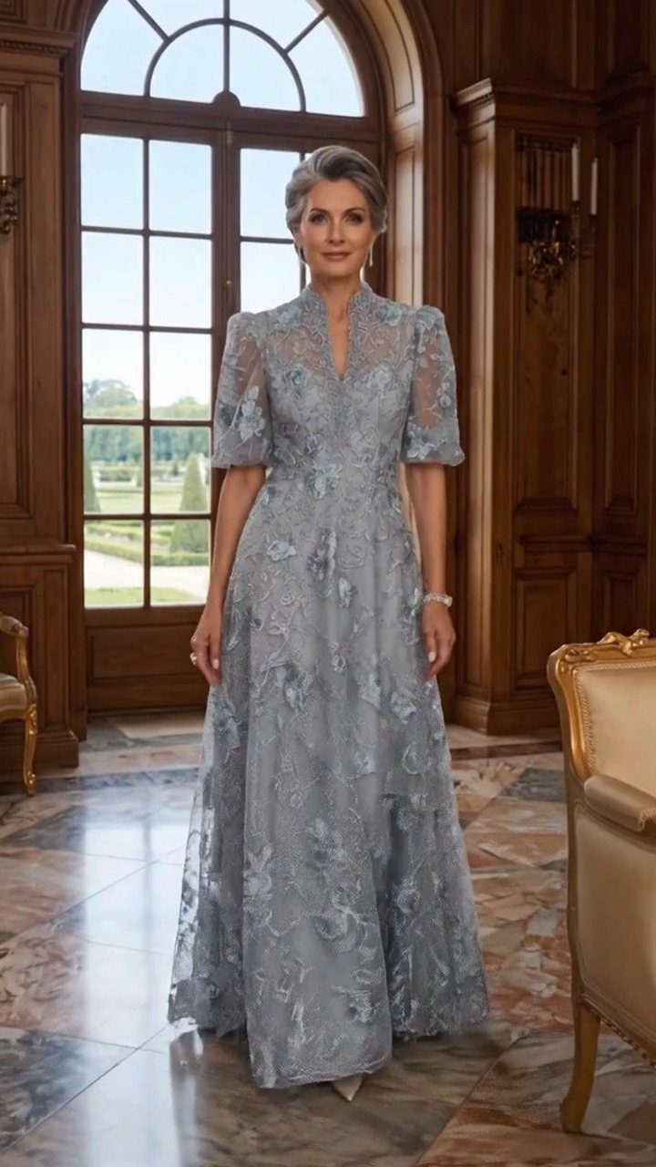 Woman in a light blue lace floor-length gown standing in a luxury room.