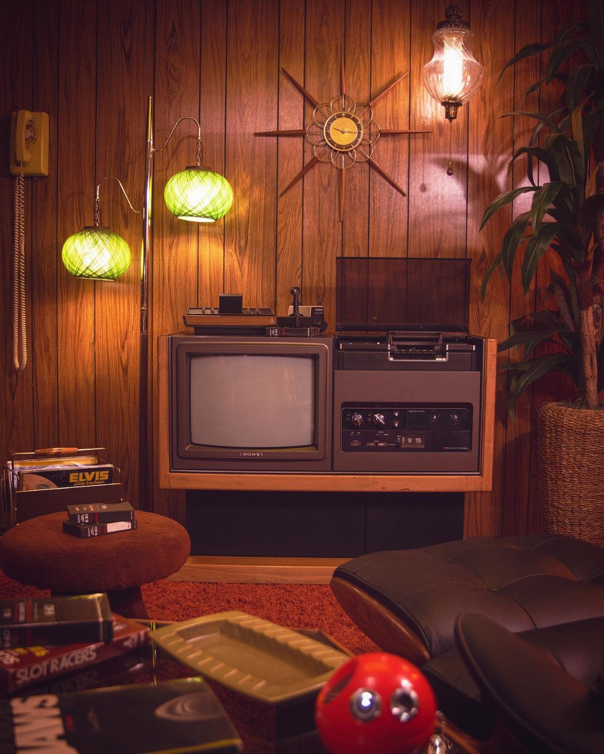 Vintage 1970s living room with wood paneling, retro TV, and starburst wall clock.