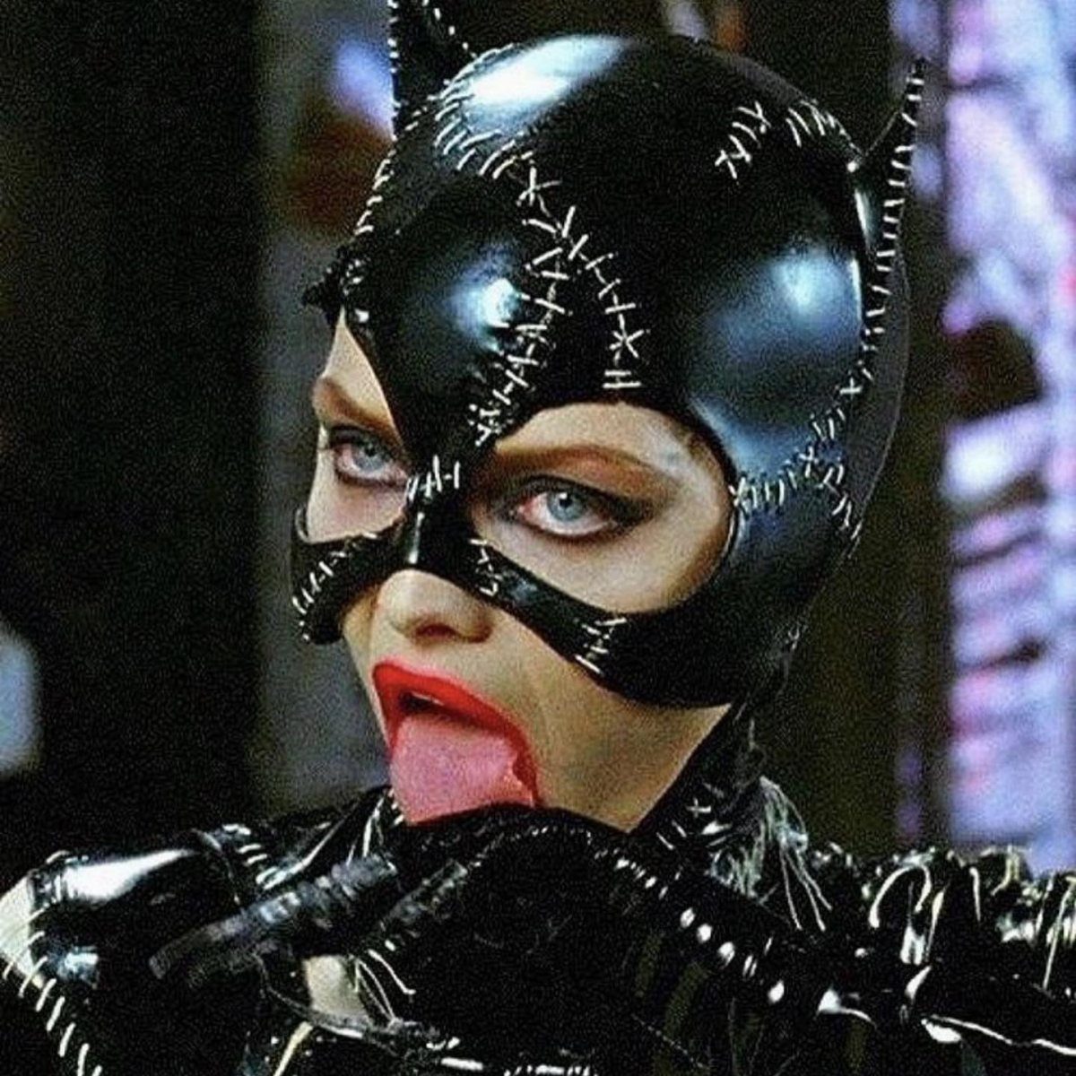 Woman in a black shiny latex Catwoman costume with a stitched mask.