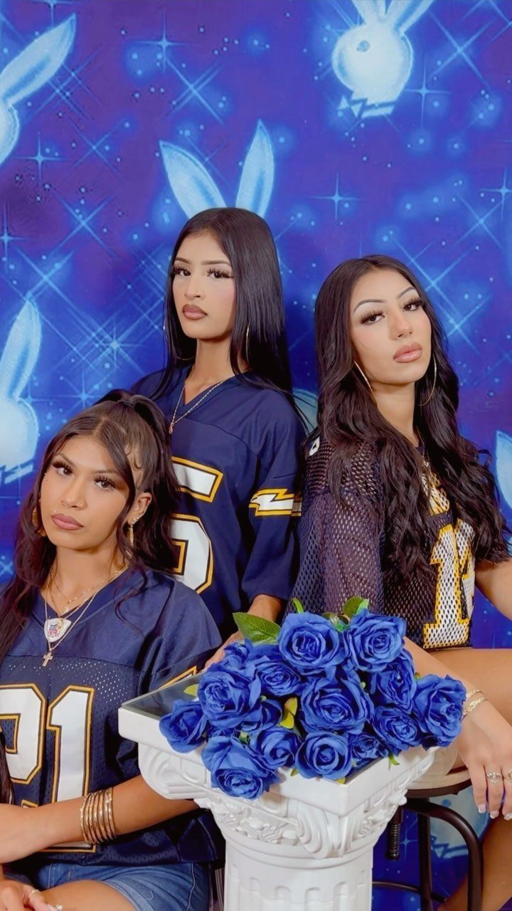Three women in sports jerseys posing before a blue starry rabbit backdrop.