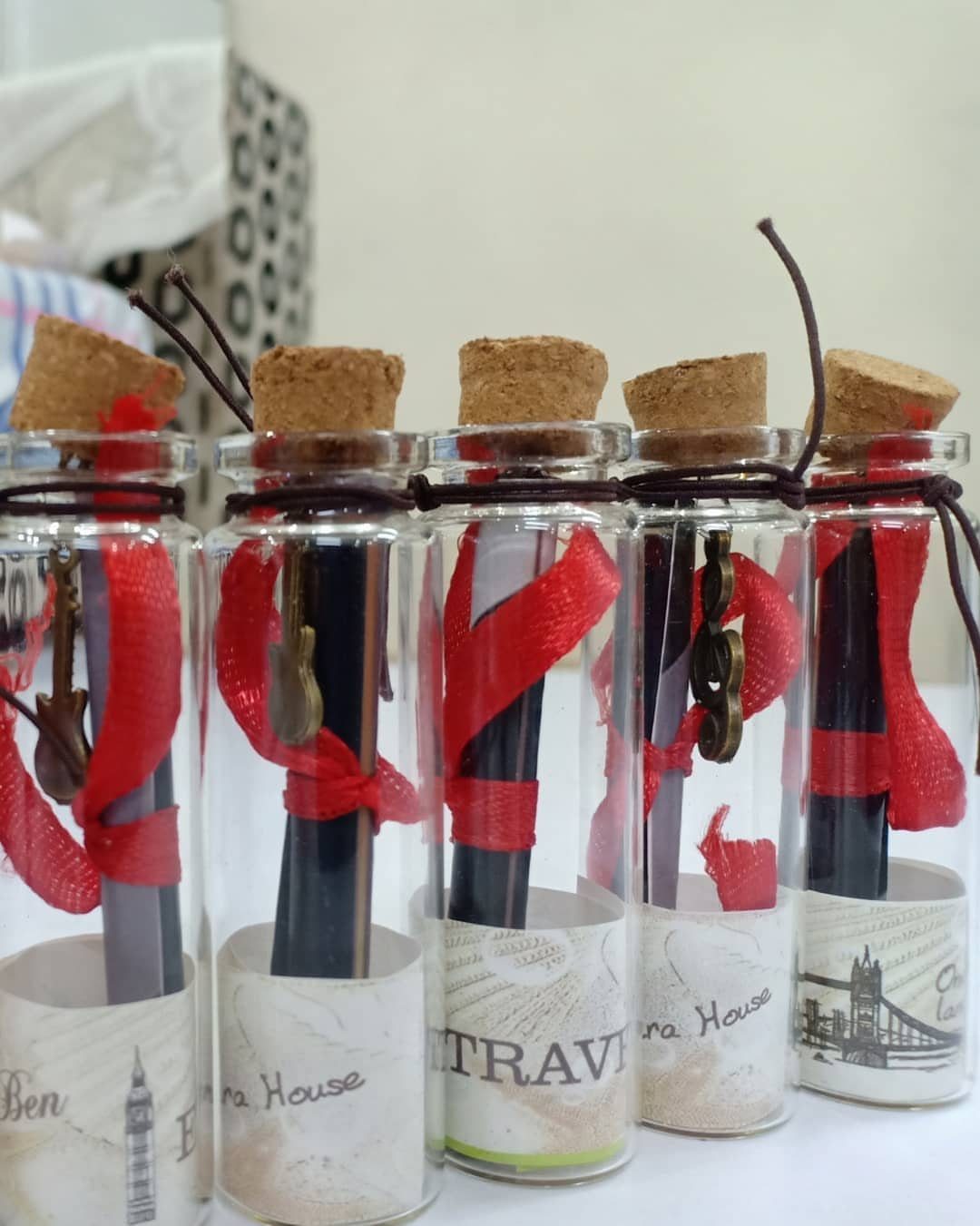 Glass bottles containing rolled scrolls, red ribbons, and small keys for a game.