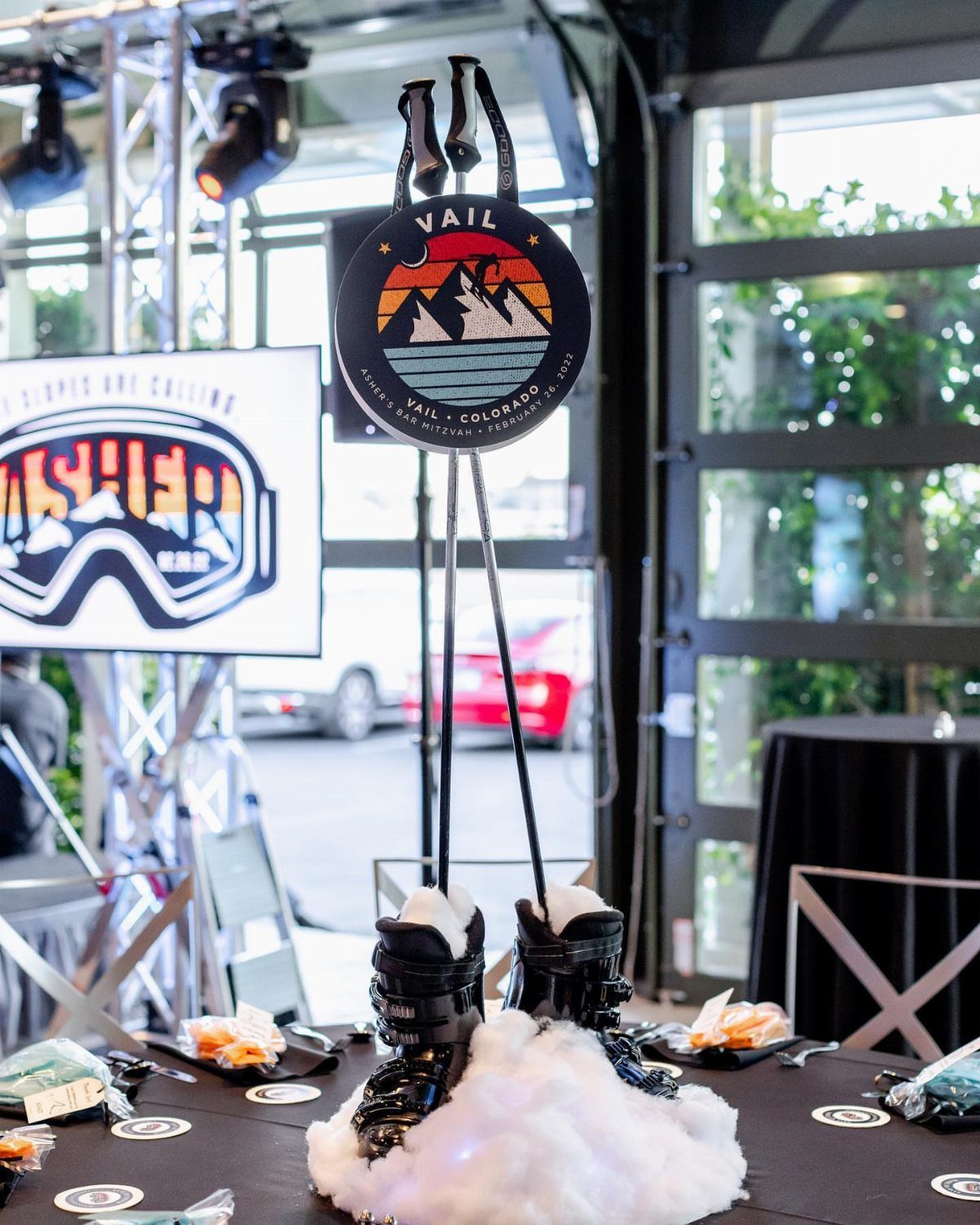 Ski boots in faux snow with a Vail logo sign as a centerpiece.