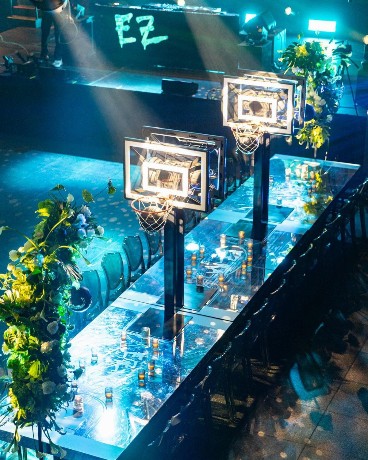 Reflective blue table with miniature basketball hoops and small candles for a celebration.