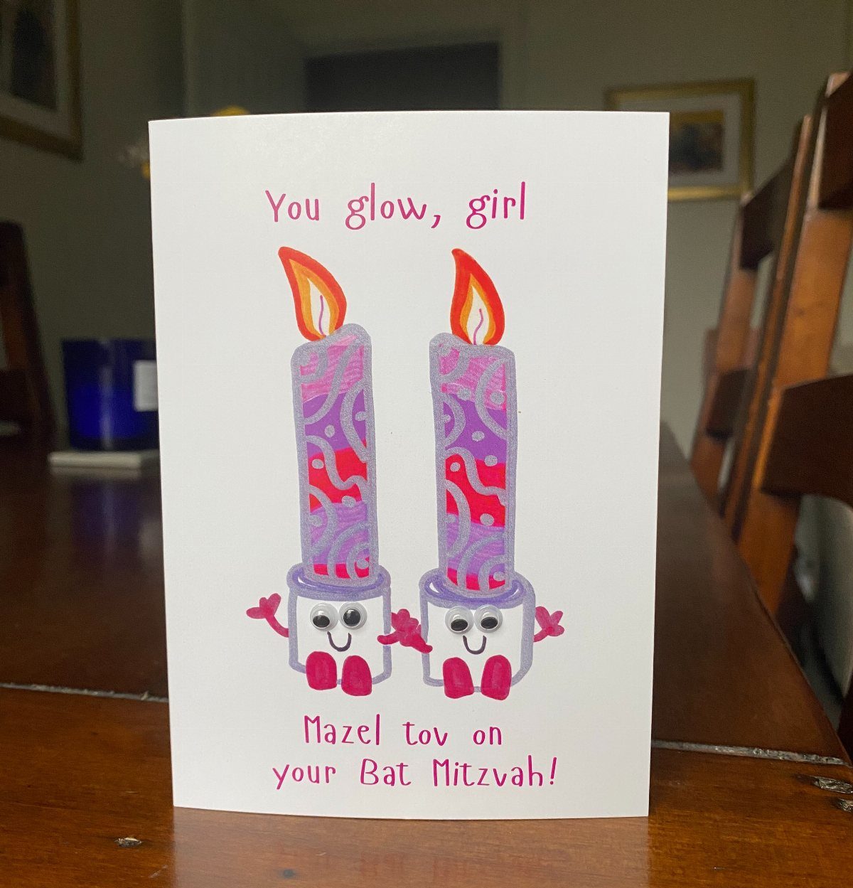 Greeting card with two smiling purple candles and Mazel Tov Bat Mitzvah text.