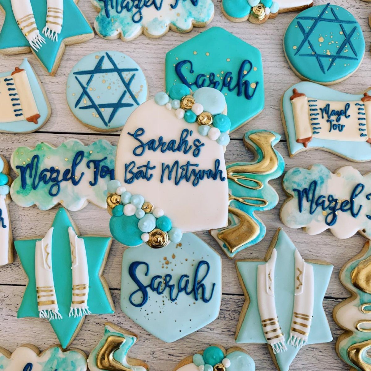 Decorated sugar cookies with Stars of David and Bat Mitzvah messages in blue and gold.
