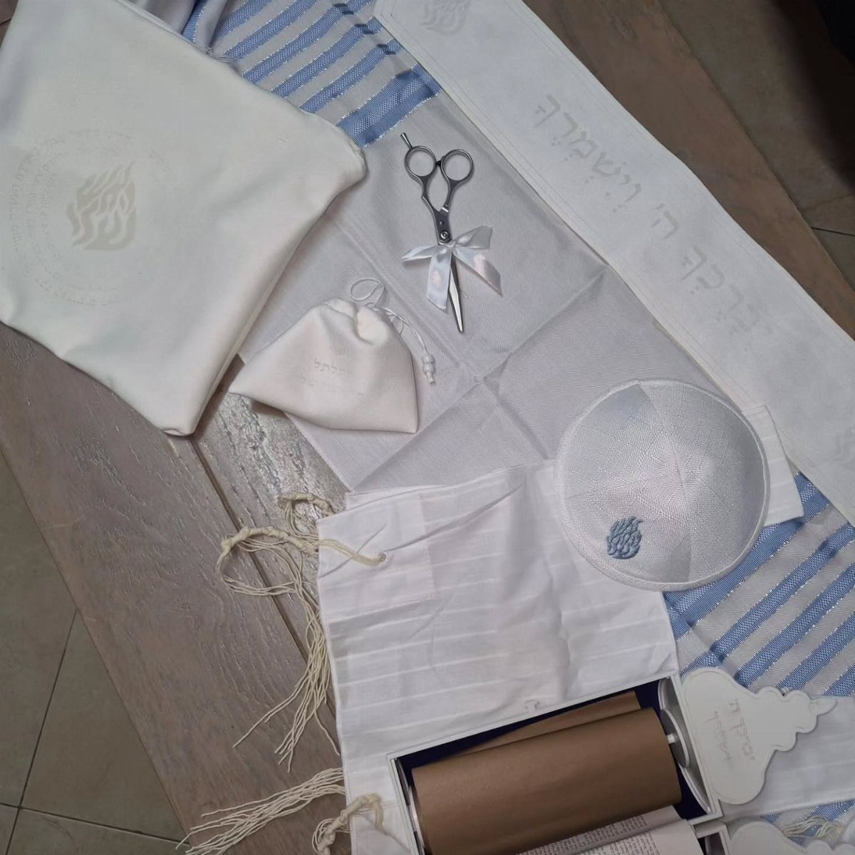 Jewish ritual items including a tallit, kippah, and Torah scroll as gift ideas.
