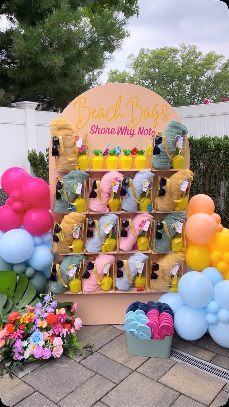 Beach bags station with colorful towels, drinks, and balloons on a stone patio