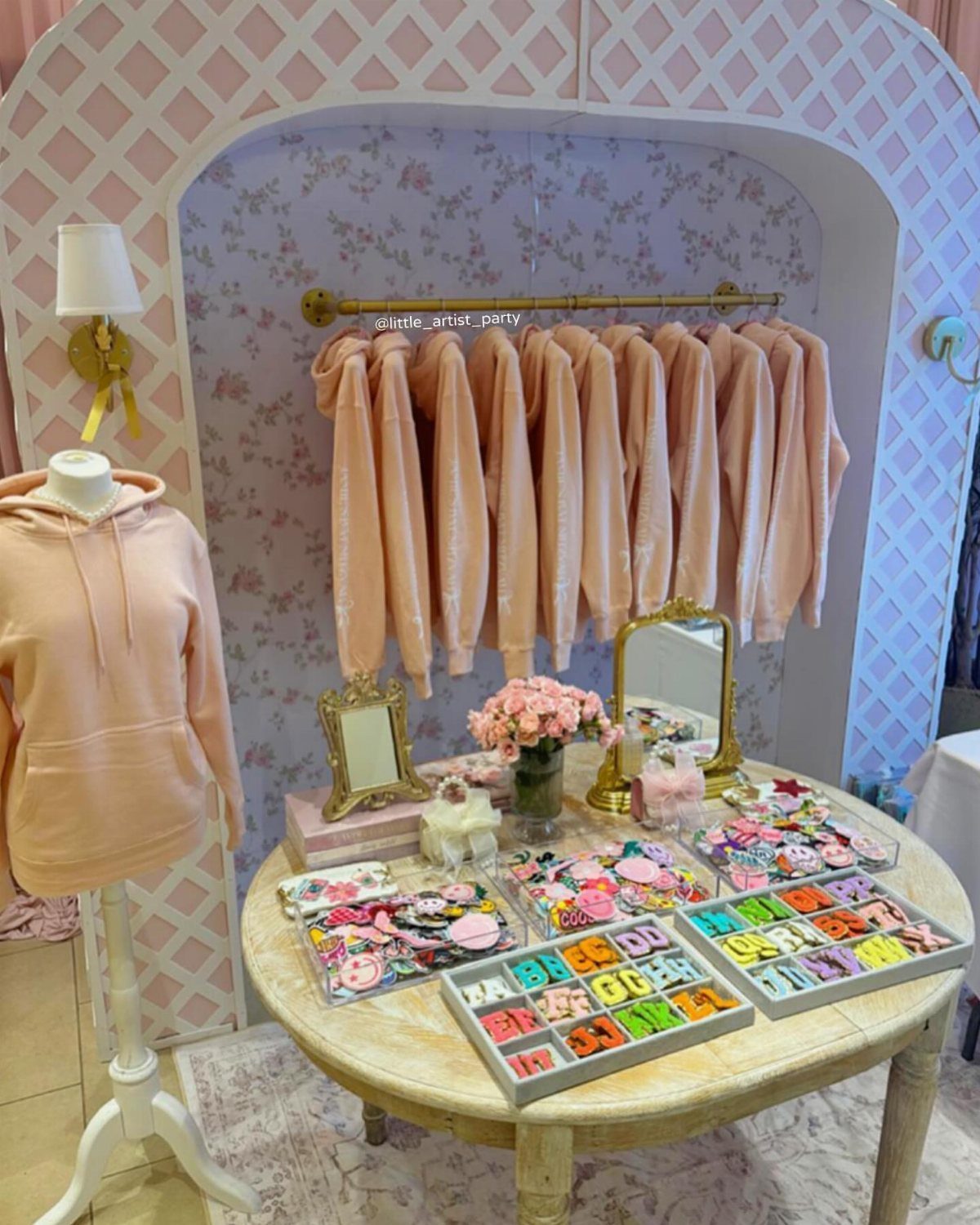 Bead trays and peach velvet hoodies arranged in a decorative party display area
