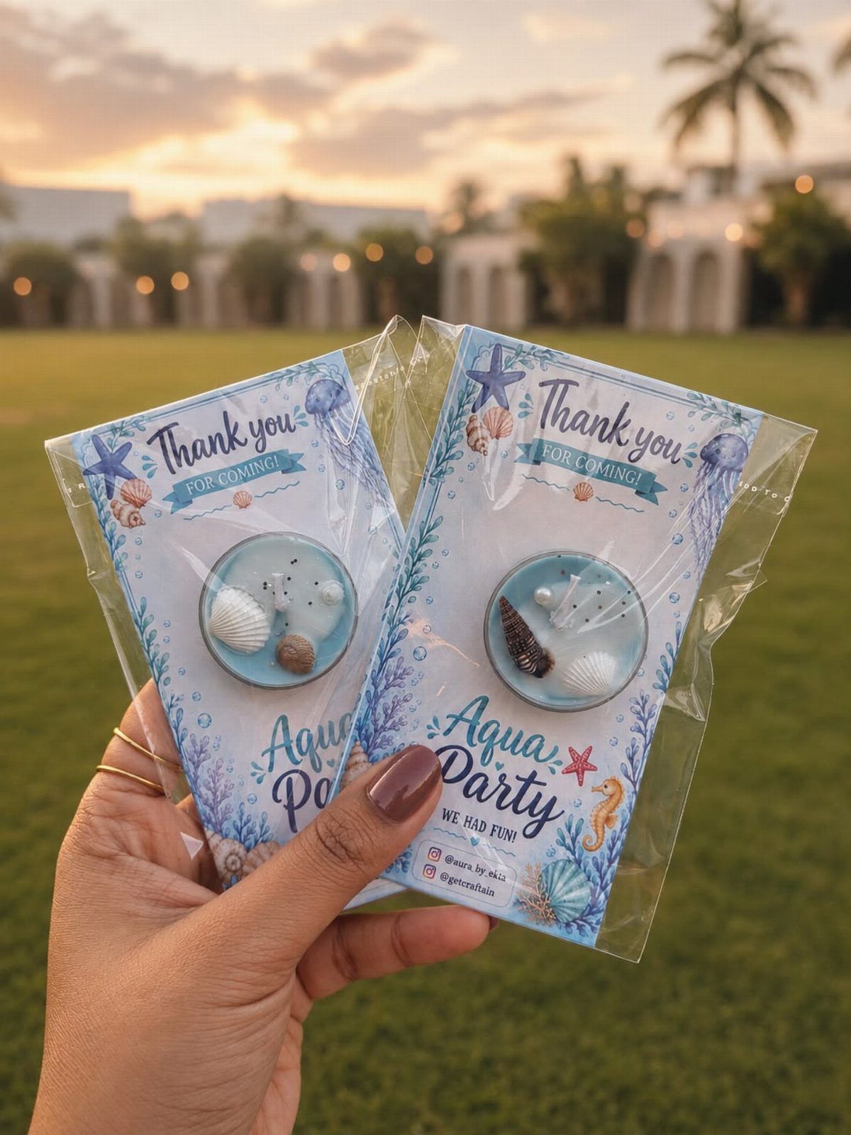 Two beach-themed party favor packets with miniature seashell dishes and thank you cards.