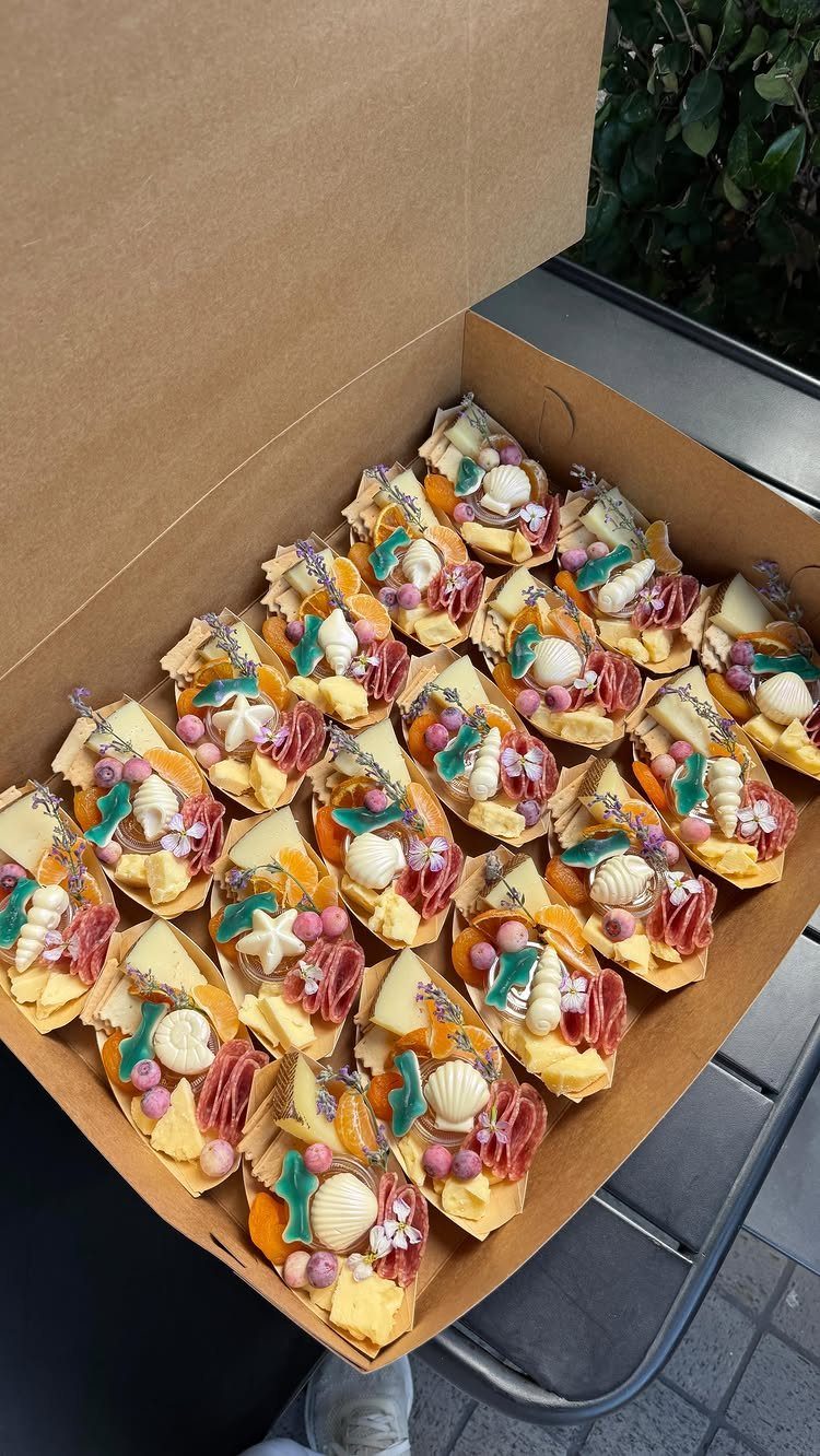 Appetizer portions with cheese and meats decorated with seashells in a cardboard box