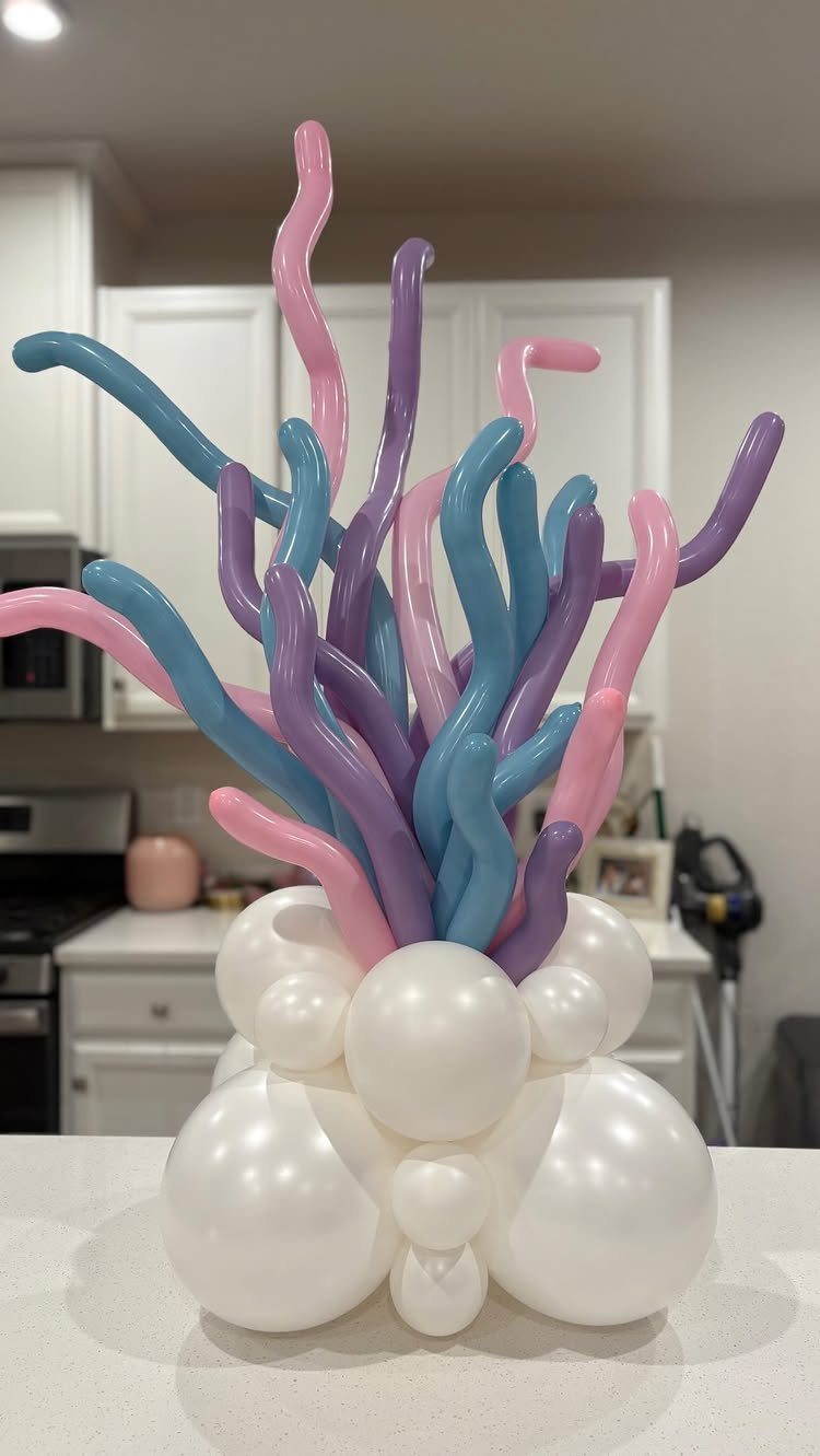 Balloon coral sculpture with blue, purple, and pink twisting balloons on white base.