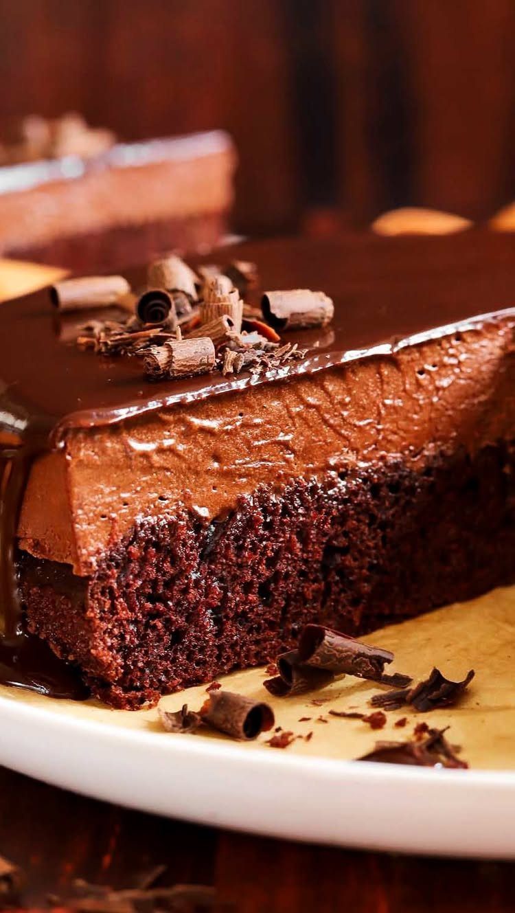 Chocolate truffle cake with glossy glaze and mousse filling on white plate