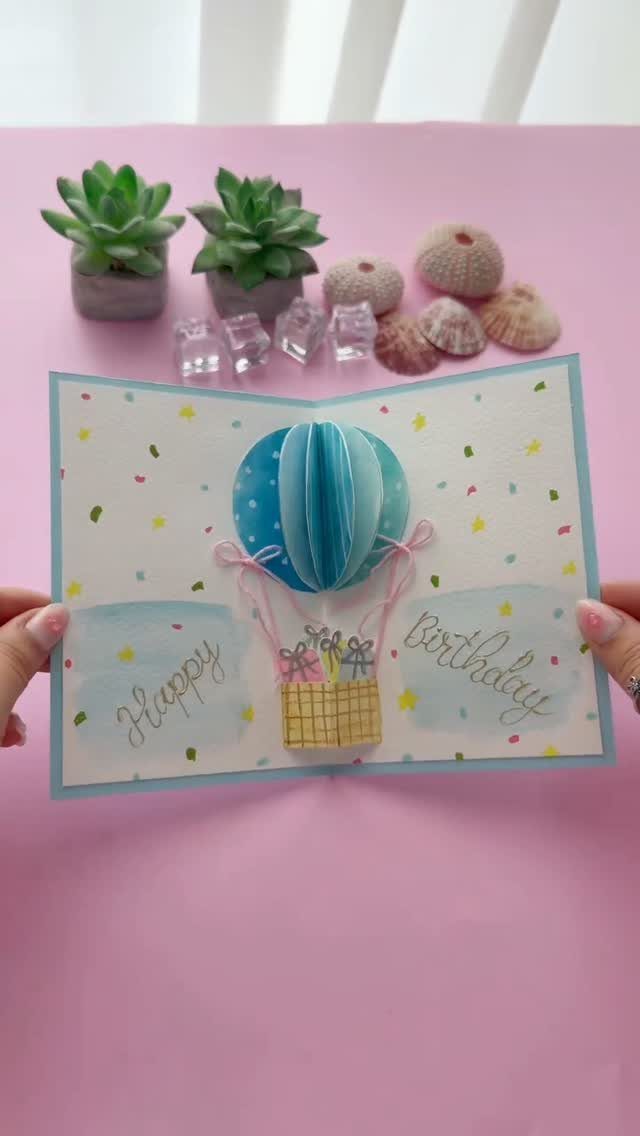 Handmade birthday card with a blue 3D pop-up hot air balloon and confetti.