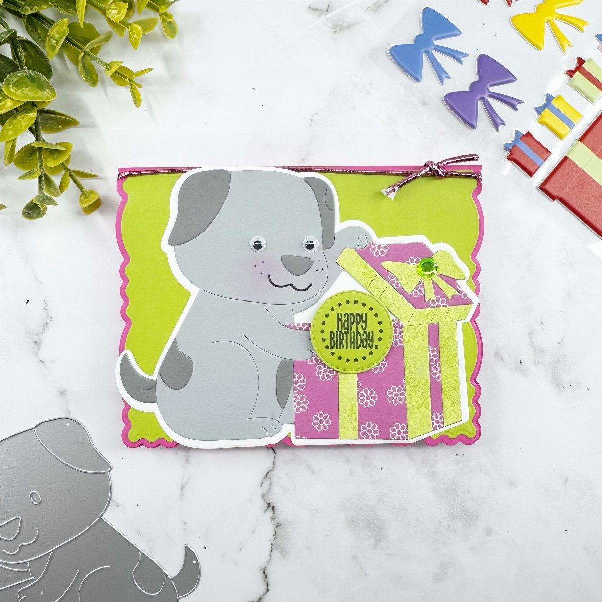 Handmade birthday card with a grey puppy holding a purple gift box.