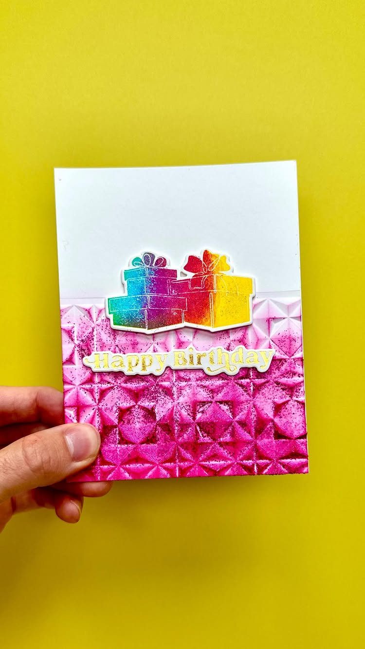 Handmade birthday card with pink glitter texture and rainbow gift box illustrations.