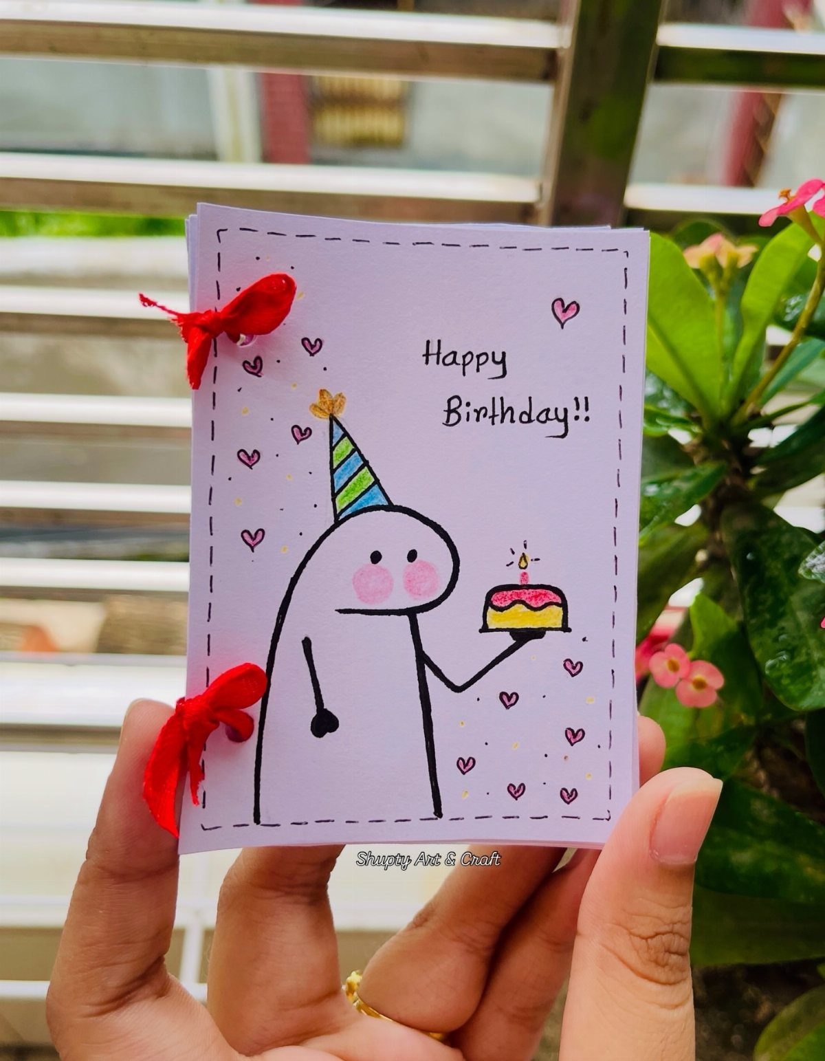 Handmade purple birthday card with a cute character holding a small cake.