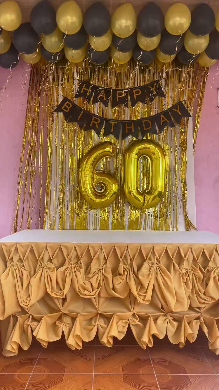 Gold gathered table skirt with birthday balloons and fringe backdrop for 60th birthday.
