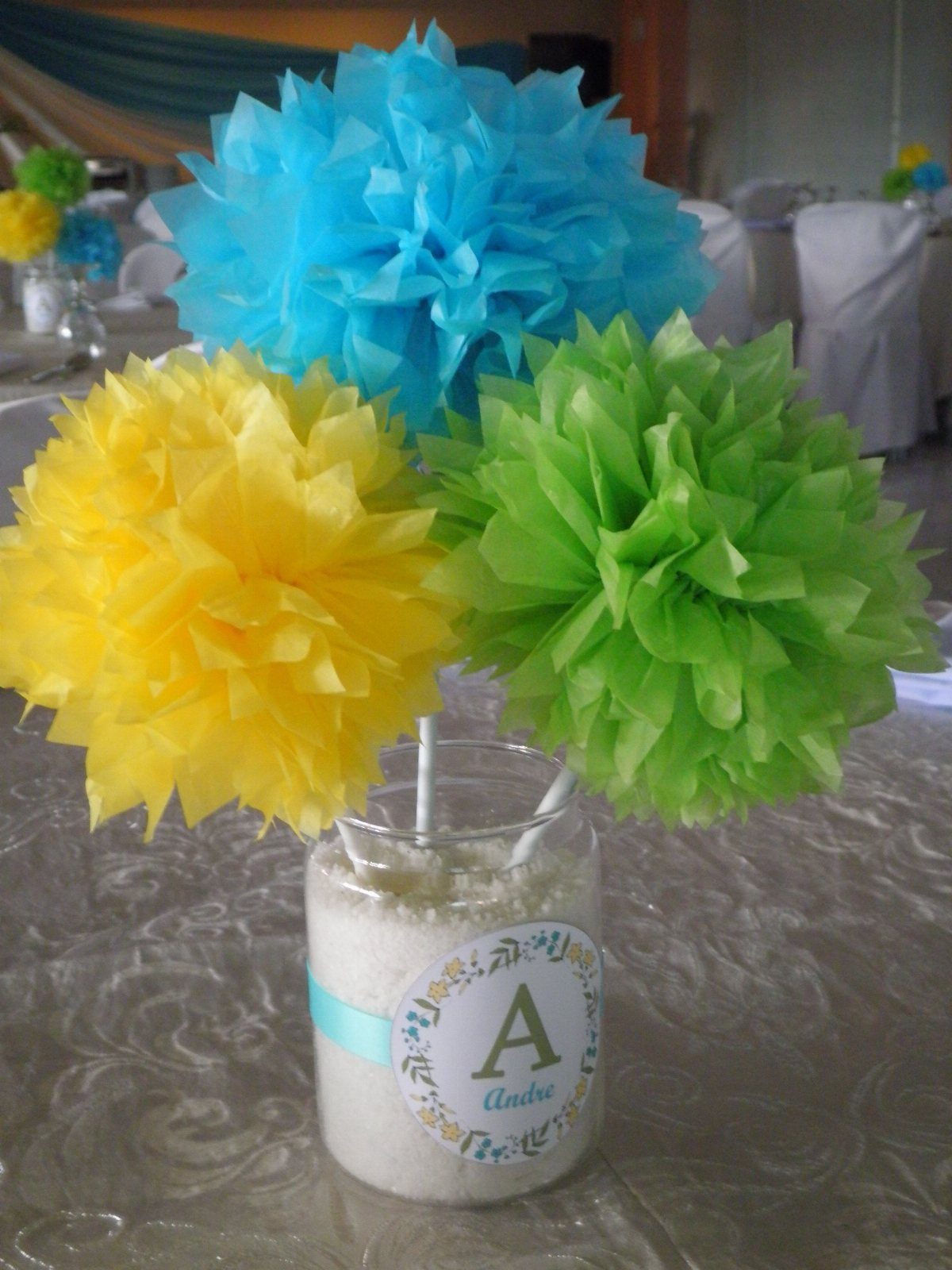Colorful tissue paper pom-poms in a mason jar as a table centerpiece.