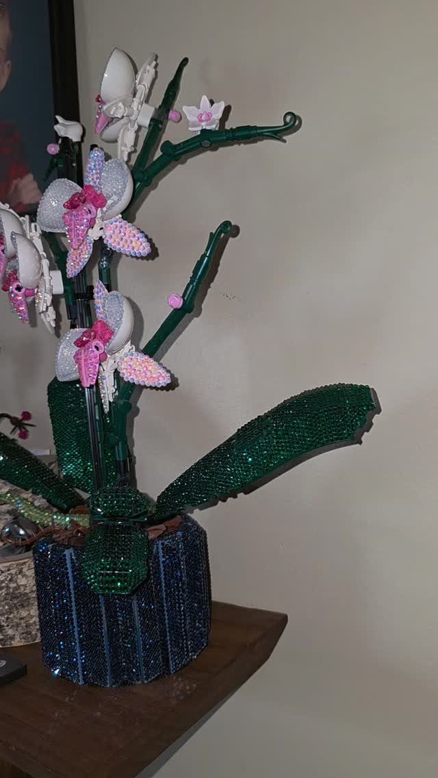 Beaded orchid sculpture with pink and white flowers in a blue pot