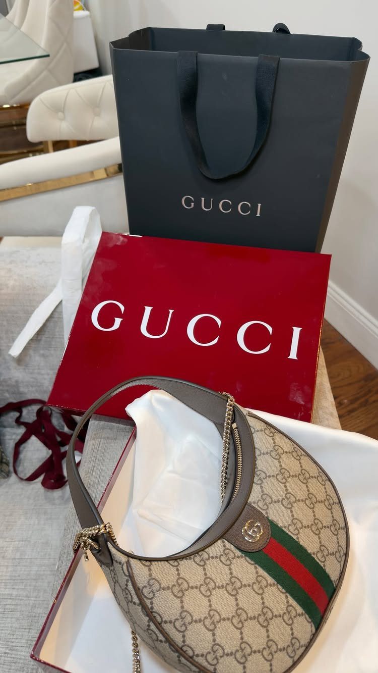 Gucci handbag, red gift box, and black shopping bag as luxury birthday gifts.