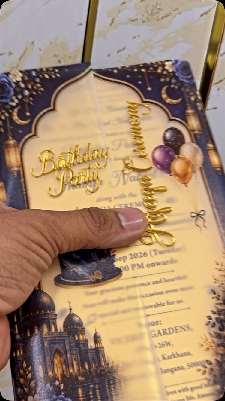 Gold-foiled birthday invitation card with blue accents, balloons, and palace illustration.