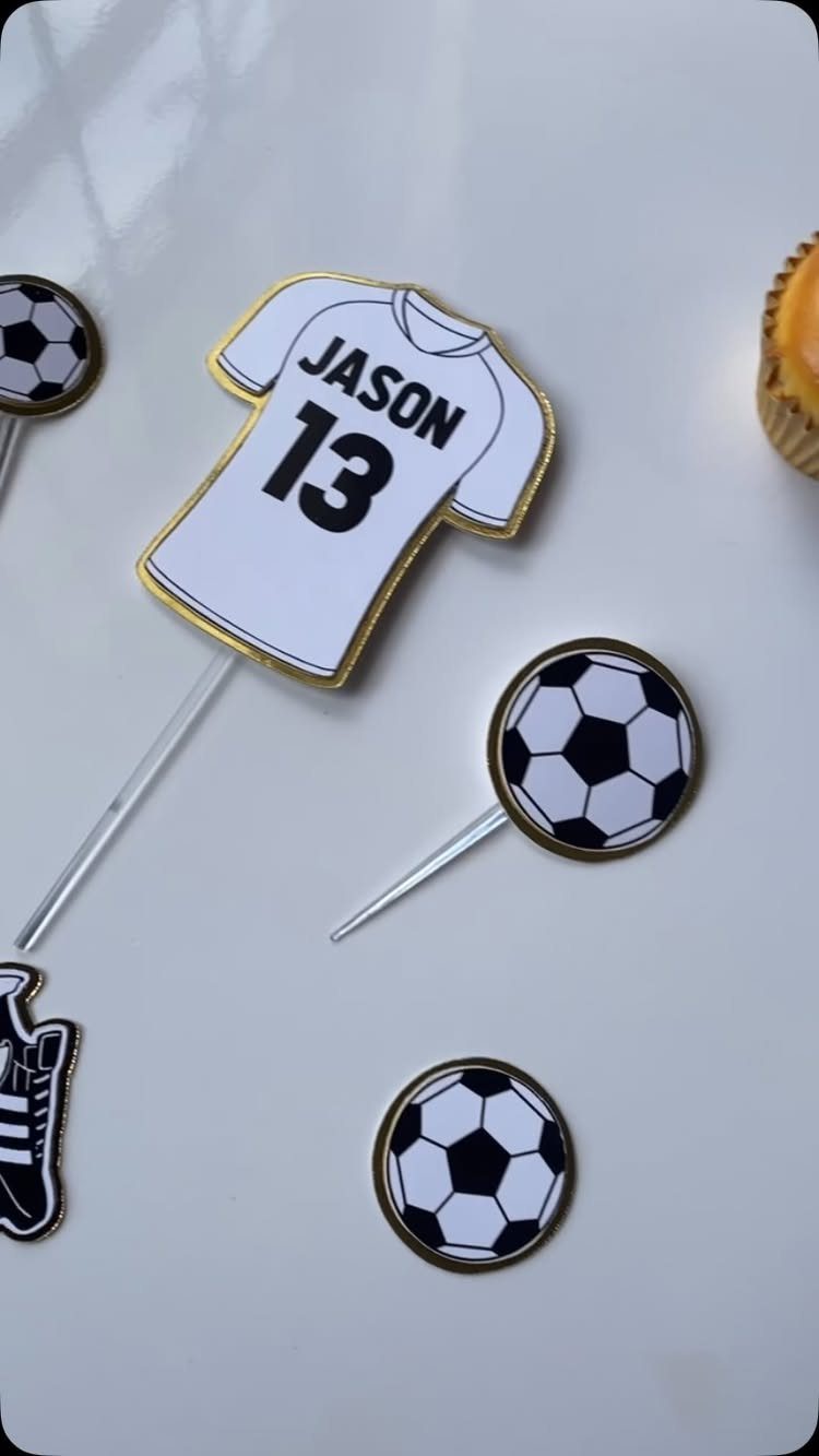 Soccer-themed cake toppers including a personalized jersey and soccer balls on sticks.