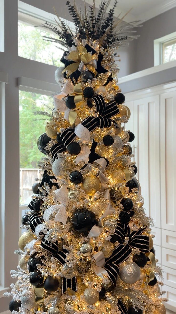 Christmas tree decorated with black and gold ornaments and striped ribbons