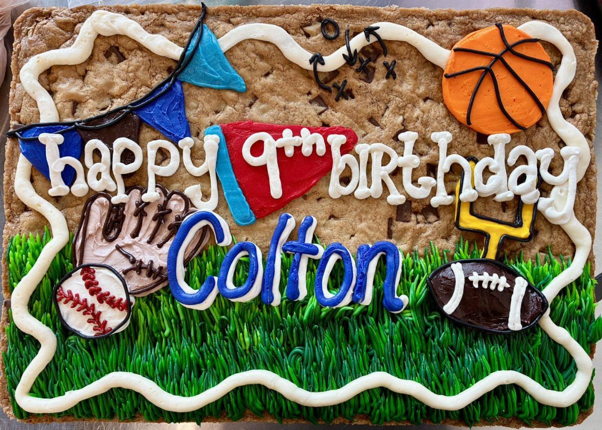 Sports themed cookie cake with basketball, football, and baseball frosting decorations for Colton.