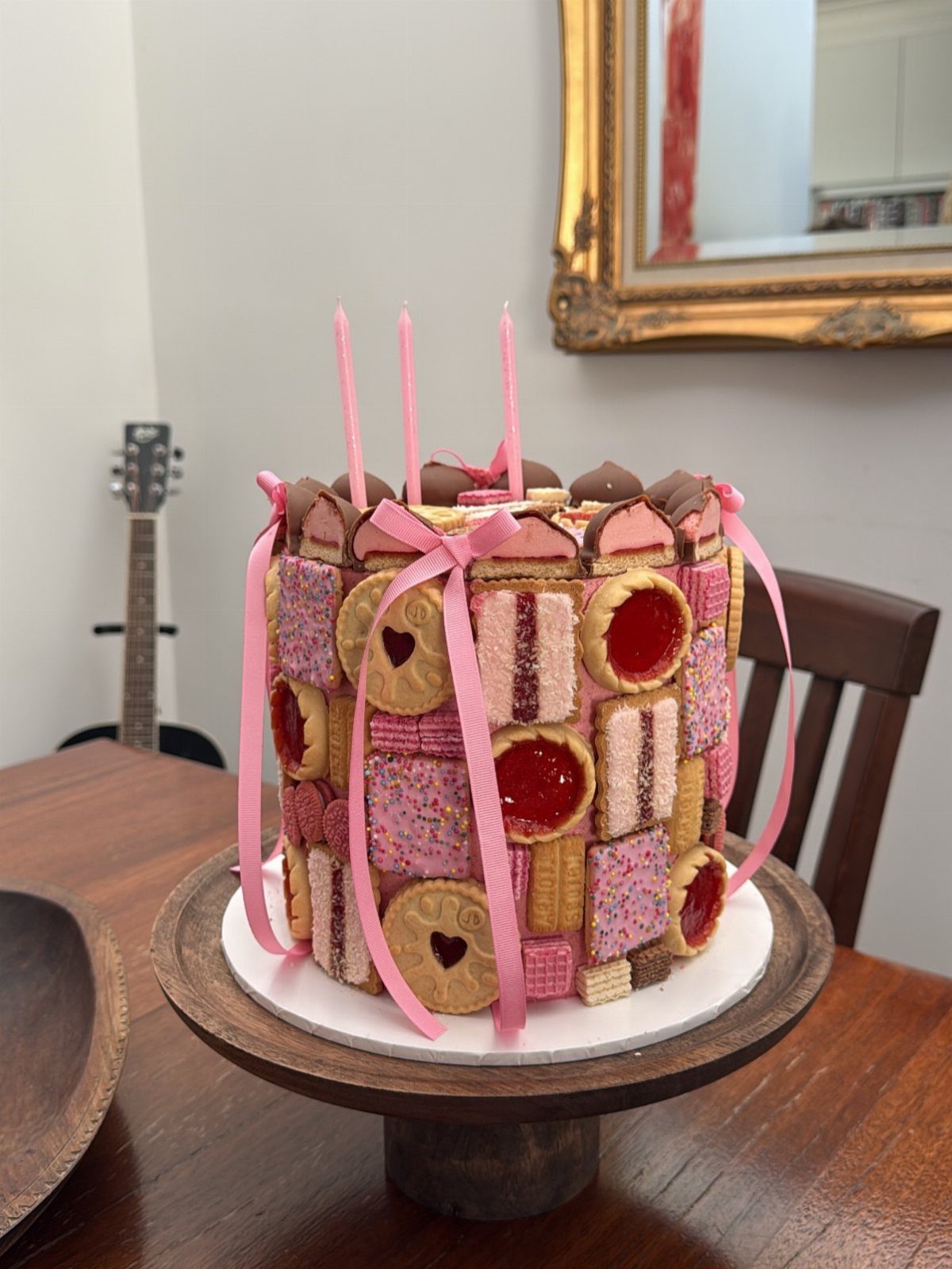 Cookie cake covered in pink and tan biscuits tied with pink ribbons