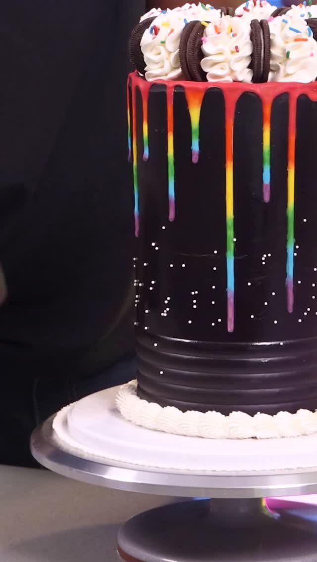 Dark chocolate cake with rainbow drips and Oreo cookies on top.