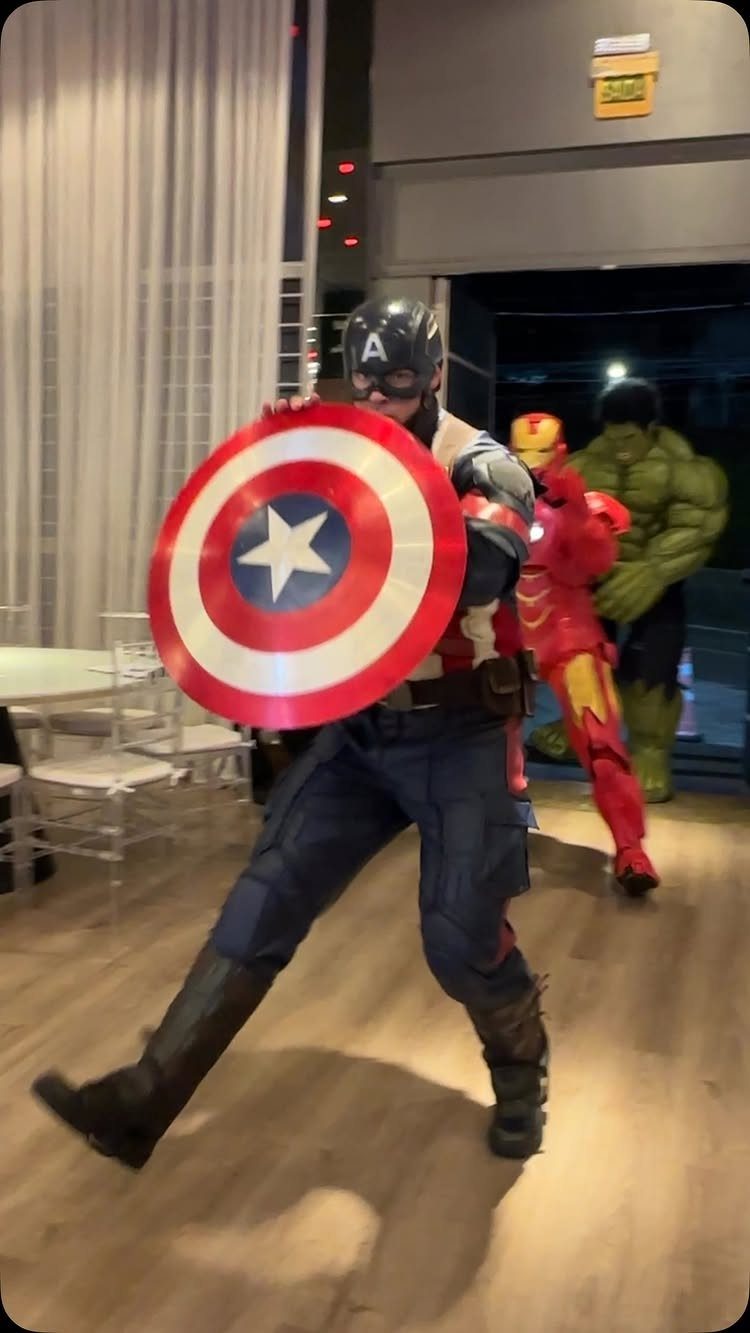 People dressed as Captain America, Iron Man, and the Hulk in superhero costumes.