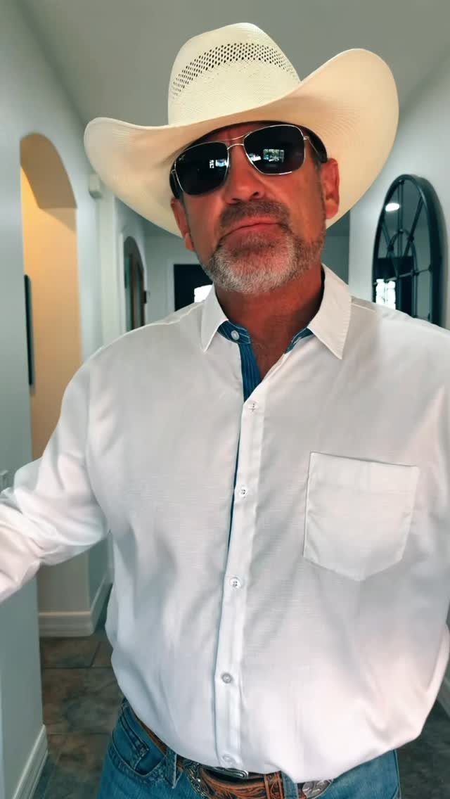 Man dressed in western attire with a white cowboy hat and sunglasses.