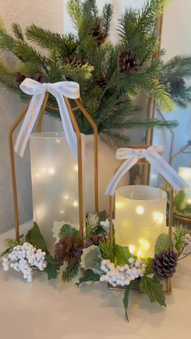 Gold lanterns with white bows and fairy lights decorated with winter greenery