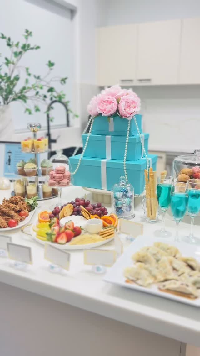 Turquoise gift boxes with pearls and pink roses atop a glamorous brunch spread.